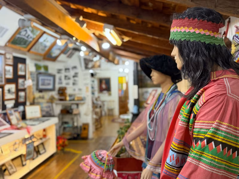 Mannequins in colorful Seminole patchwork clothing and a beaded headband in the gallery