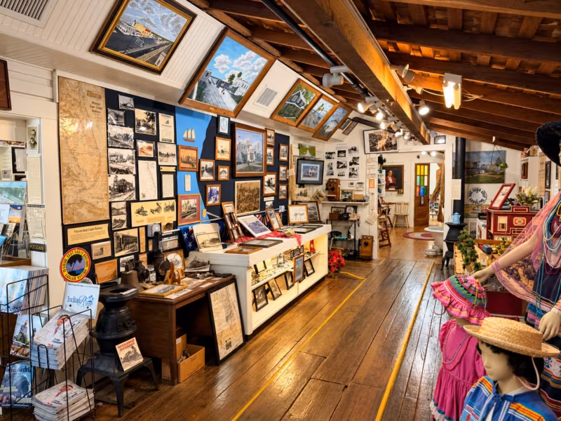 The museum's long main gallery with framed photographs on the walls, display cases and mannequins in Seminole dress